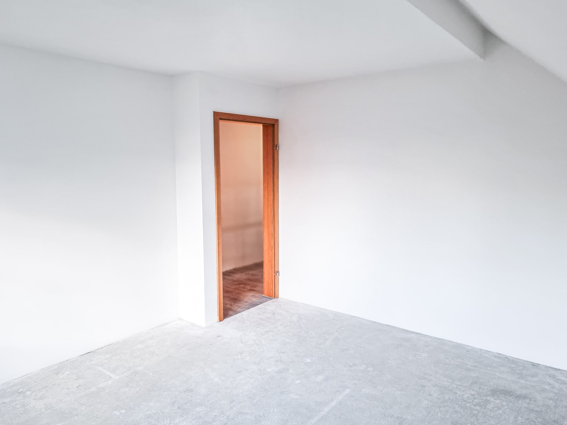 Das Bild zeigt ein modernes Trockenbau-Projekt, bei dem eine Trockenbauwand in einem Wohnzimmer installiert wird. Zwei Handwerker arbeiten zusammen, um die Gipskartonplatten zu montieren und zu befestigen. Werkzeuge und Materialien liegen in der Nähe, während im Hintergrund bereits fertige Trockenbauwände zu sehen sind.